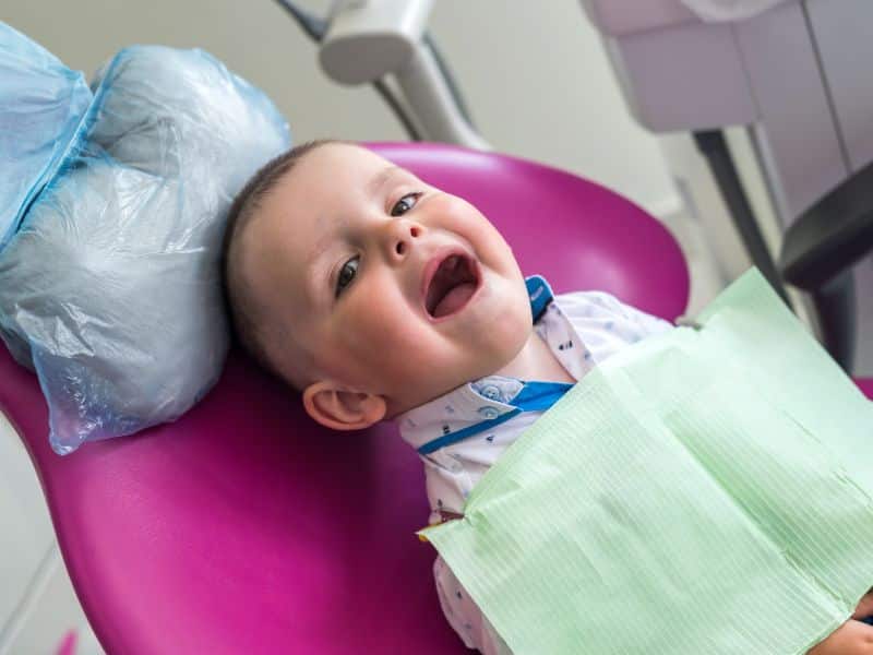 First dental visit for toddlers — young child smiling in dental chair at Smiles for Kids Cumming GA
